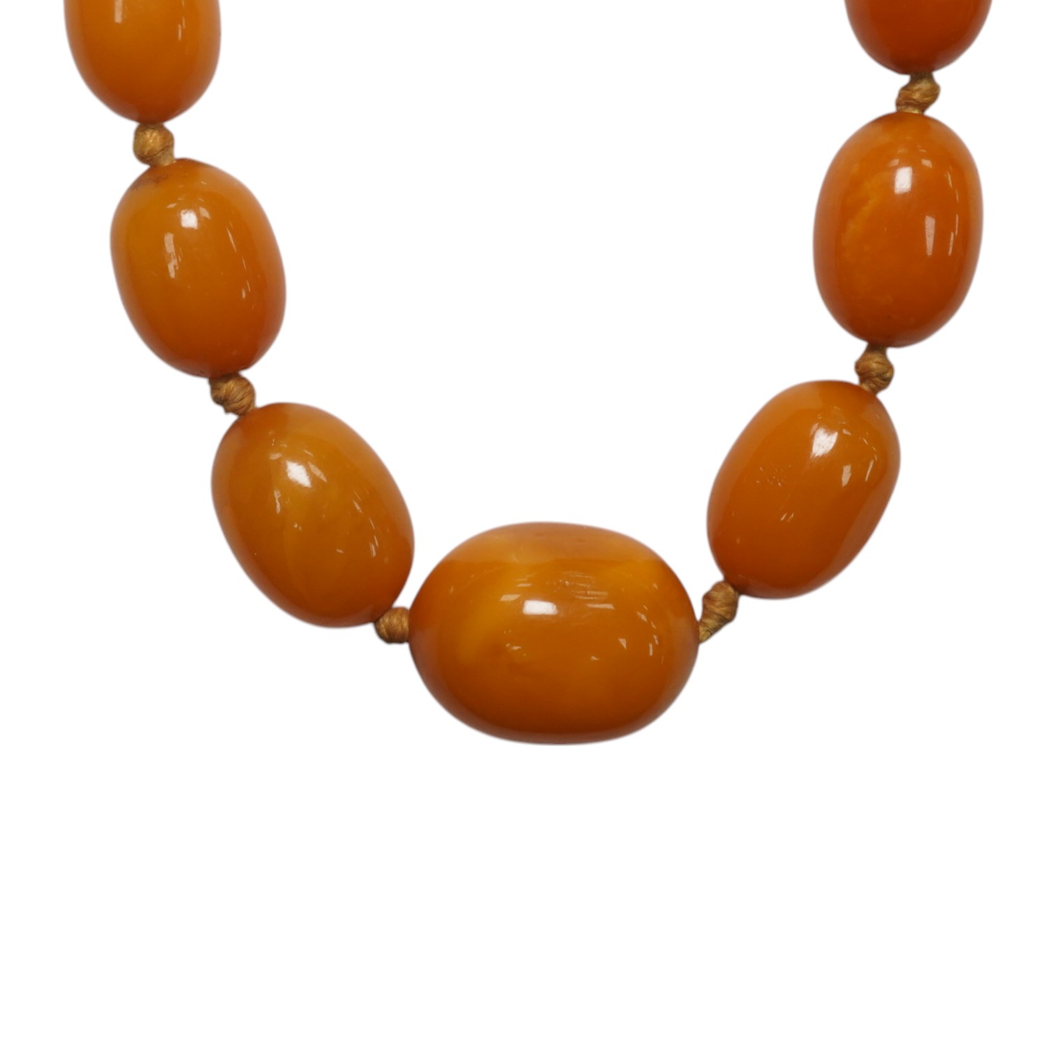 A single strand graduated oval amber bead necklace, 62cm, gross weight 34 grams. Condition - poor to fair